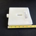 Heating unit on a table with a measuring tape next to it to show the size of the heating pack