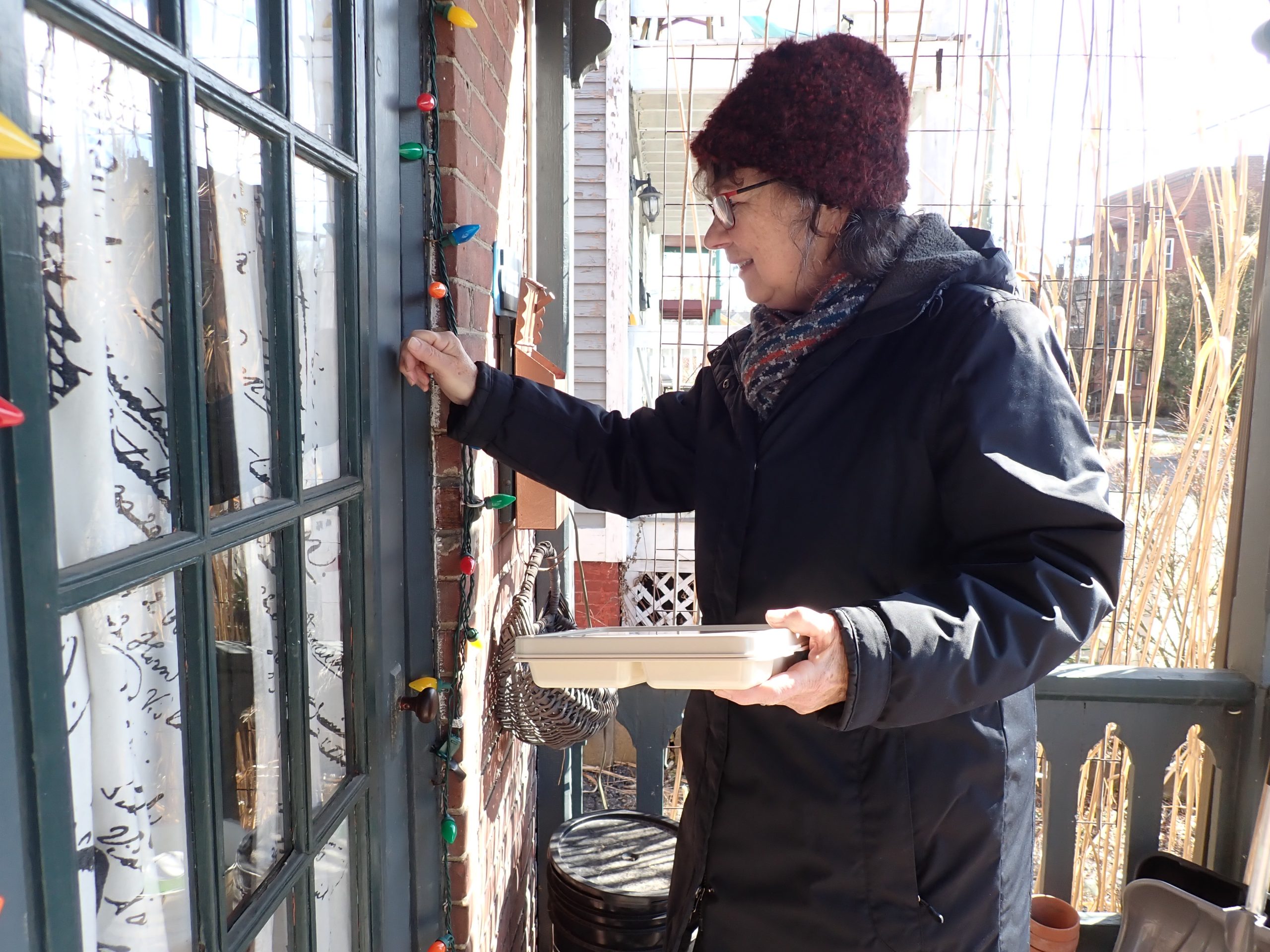 Woman delivering a meal using the MOW Store Meals on Wheels tray