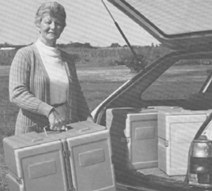 Volunteer loading Nutri-Systems meal transporters into a car